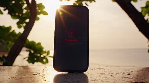 Smartphone Showing Overheating Warning Standing On Outdoor Table Under Strong Tr Stock Footage 330884033