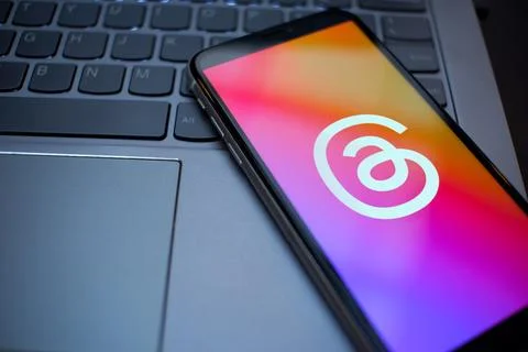 Smartphone Showing Threads App Logo on a Laptop Keyboard Stock Photos