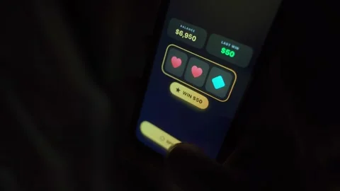 Smartphone slot machine app spinning to three stars and jackpot win in dark Stock-Footage 342912487