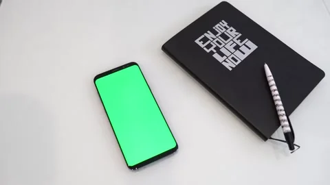 Smartphone on the table and notepad. Chromakey. White background Stock Footage 249757101