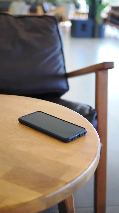 Smartphone on a table in a cafe. lost smart phone concept Stock Footage 343805404