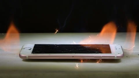 Smartphone on the table flashes and sparks due to battery overheating. Danger of Stock Footage 309485607