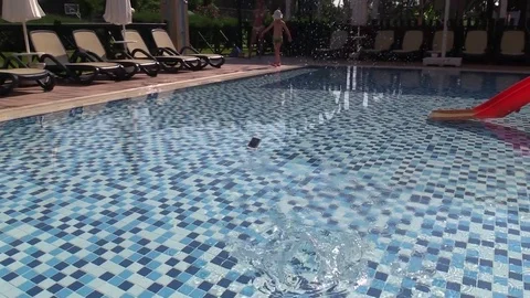 Smartphone is thrown into the pool water Stock Footage 78589430