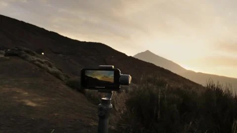 Smartphone on a tripod with active screen shooting sunset in the mountains Video stock 309172430