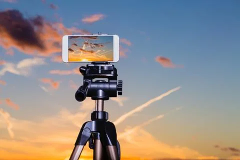 Smartphone on tripod capturing image of stunning sundown Stock Photos