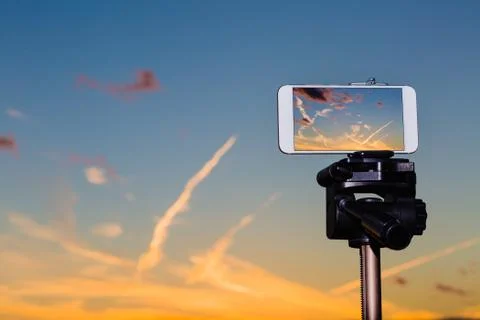 Smartphone on tripod capturing image of stunning sundown Stock Photos
