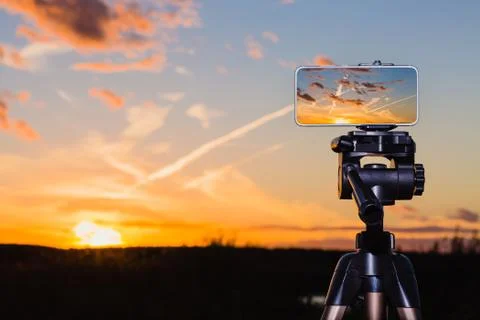 Smartphone on tripod capturing image of stunning sundown Stock Photos