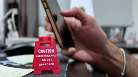 Smartphone Use Beside Red Caution Sign on Modern Office Desk Видео 333438542