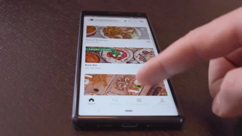 Smartphone user browsing through online food options on Uber Eats app - Stock Footage 148453858