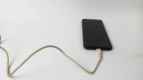 Smartphone utilizes a cable for charging Stock Footage 313381417