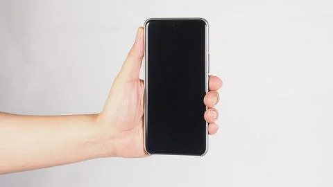 A smartphone vertically with one hand on white background. Stock Photos