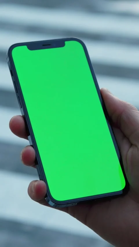 Smartphone with a vibrant green screen tailored for creative applications and Stock Footage 314151196