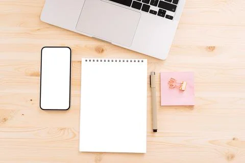 Smartphone with white screen for text or advertising on wooden table with laptop Stock Photos