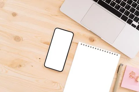 Smartphone with a white screen for text or advertising on a wooden table with a Stock Photos