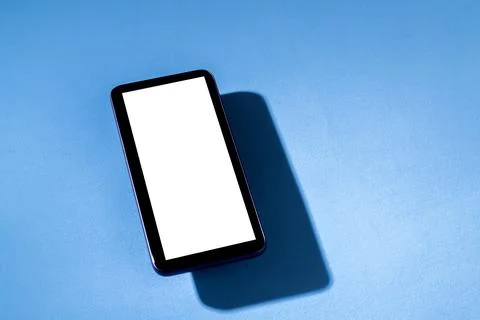 Smartphone with white screen on top of blue table. Cell phone concept. White  Stock Photos