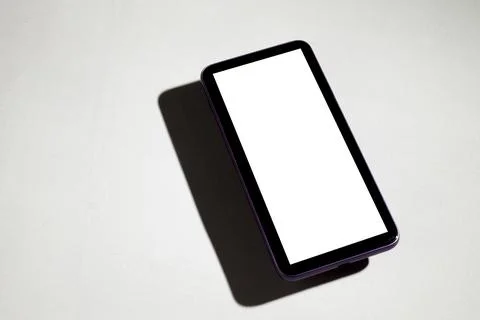Smartphone with white screen on top of gray table. Cell phone concept. White  Stock-Fotos