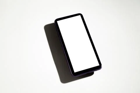 Smartphone with white screen on top of gray table. Cell phone concept. White  Stock-Fotos
