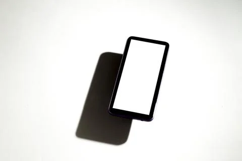Smartphone with white screen on top of gray table. Cell phone concept. White  Stock Photos