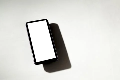 Smartphone with white screen on top of gray table. Cell phone concept. White  Stock Photos