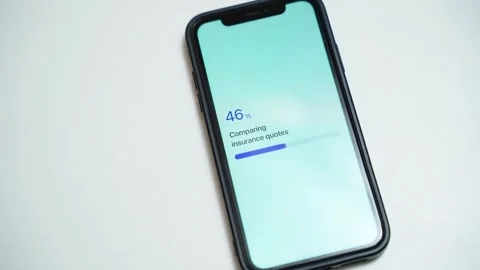 Smartphone on white table with insurance quote comparison stuck at 70 percent. Video stock 342911111