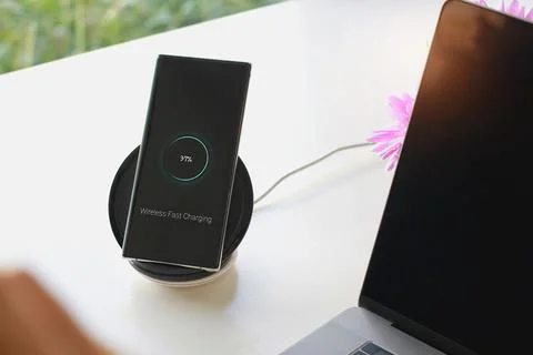 Smartphone wireless charging using wireless charging pad new technology at .. Stock Photos