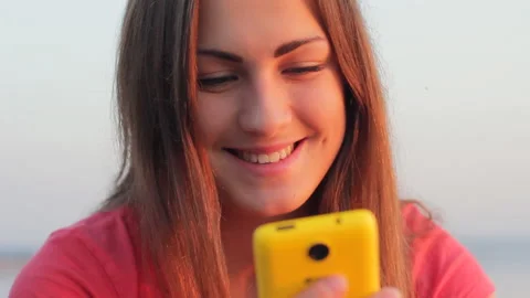 Smartphone woman texting using app on smart phone close up face at beach sunset Stock Footage 104754136