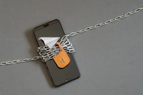 A smartphone wrapped in chains with a lock. No service. A broken phone Stock Photos