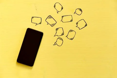 Smartphone on yellow background with text bubbles around. Messaging, texting Stock Photos