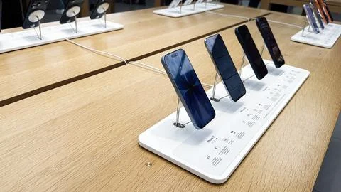 Smartphones iPhone on display in a modern electronics store showroom with a.. Stock Photos