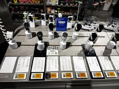 Smartwatch display on electronics store counter with multiple watches and p.. Stock Photos