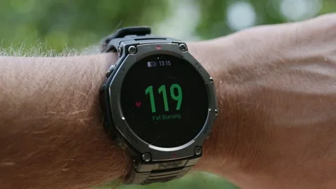 Smartwatch displaying fat burning zone heart rate 117 bpm on a male wrist Stock Footage 346073415