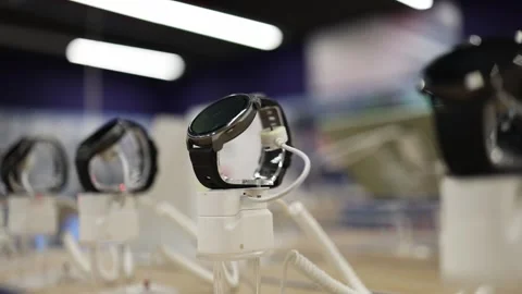 Smartwatches on security stands displayed for comparison in electronics store Stock Footage 345359271