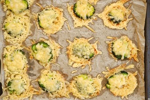 Smashed broccoli with cheese prepared on a baking sheet in a kitchen Stock Photos