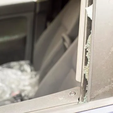 Smashed front door window of a car. Stock Photos