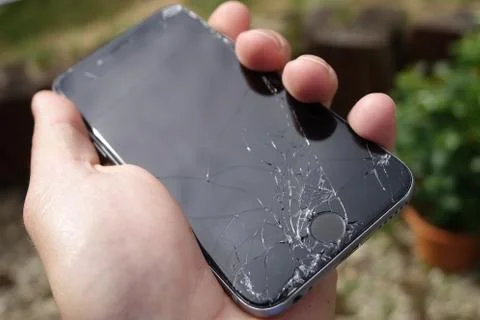 Smashed screen iPhone 6s in male hand Stock Photos