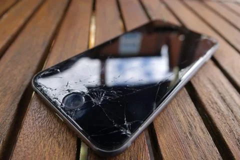 Smashed screen iPhone 6s on table Stock Photos
