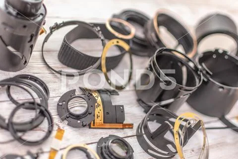A smashed up telephoto zoom lens in parts on a table Stock Photos
