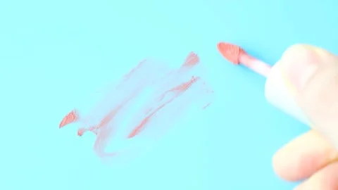 Smear liquid red lipstick and brush isolated on blue background. Stock Footage 236356624