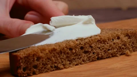Smearing butter on bread with a knife. Making a sandwich. Close-up Stock Footage 151193258