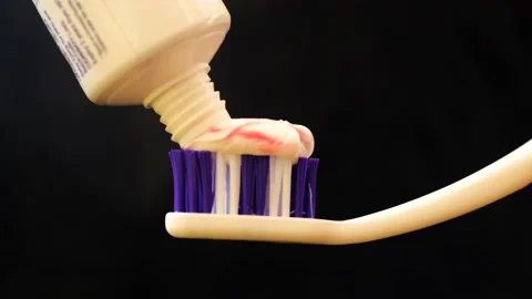 Smearing toothpaste on the toothbrush. Black background. Stock Footage 236482400