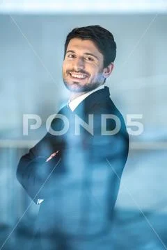 The smile businessman stand and cross hands near the window Stock Photos