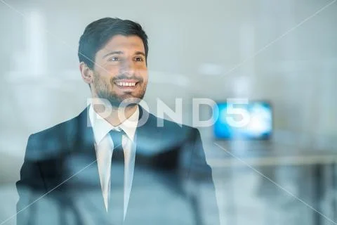 The smile businessman stand near the window Stock Photos