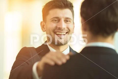 The smile businessmen hold on the shoulder in the office Stock Photos