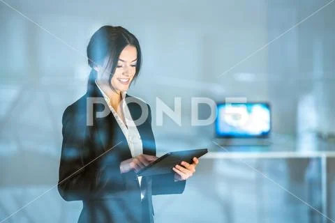 The smile businesswoman stand with the tablet over the window Stock Photos