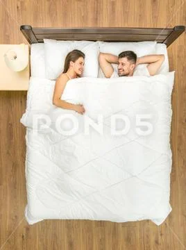 The smile couple lay on the bed. View from above Stock Photos
