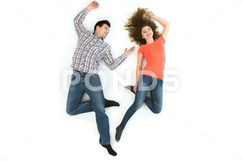 The smile couple lay on the white floor. View from above Stock Photos