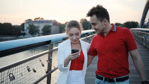 Smile couple using smartphone on bridge in city attractive beautiful handsome Stock Footage 95450103