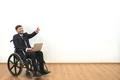 The smile disabled with a laptop gesturing on the white wall background Photo
