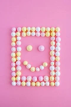 Smile in the frame in the form of a rectangle of meringue on a pink backgroun Stock Photos