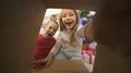 The smile girl and a boy open the box near the christmas tree 4k or 4k+ Resolution